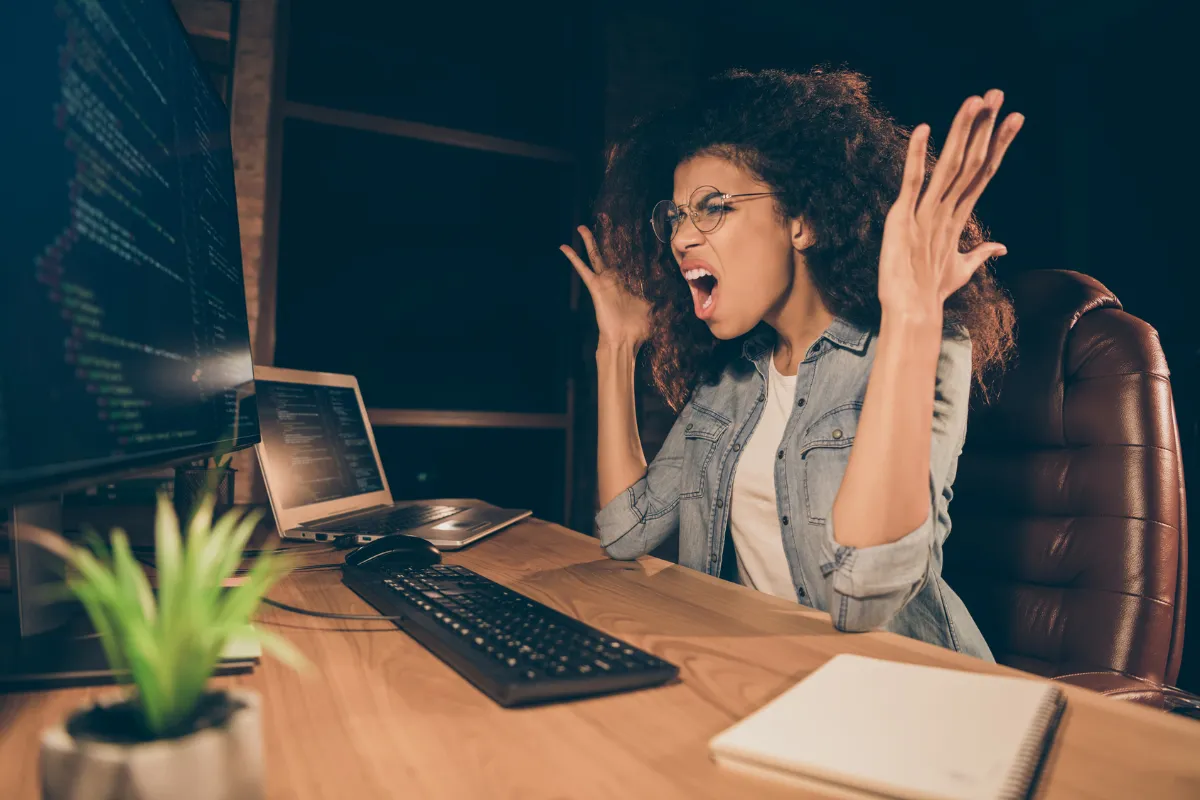 Woman throwing up her hands at her desk