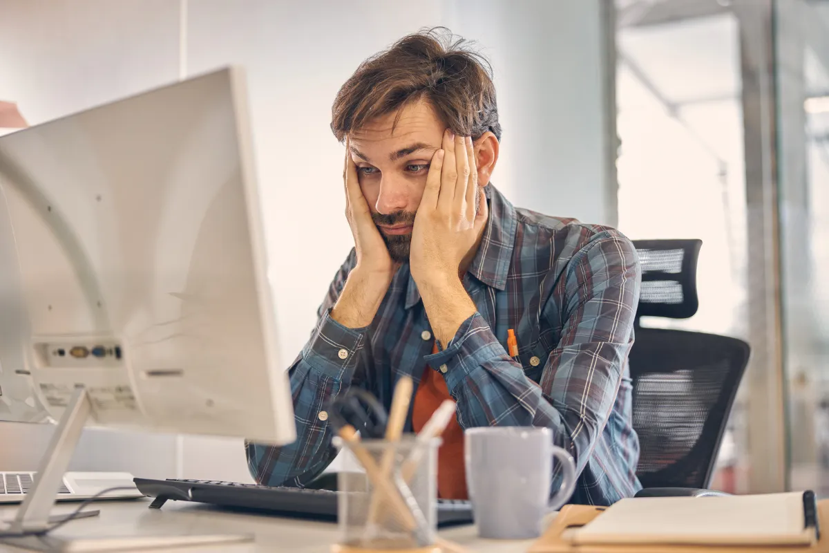 Developer with head in hands at his monitor